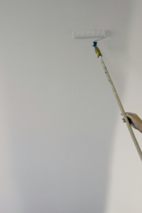 A person painting with a paint roller