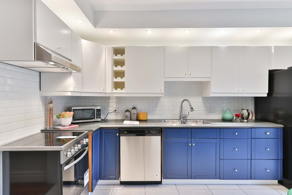 An image of a kitchen with blue and white cabinets